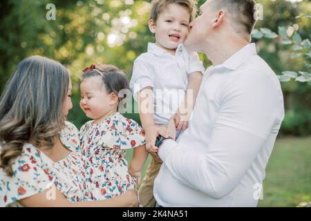 La madre asiatica tiene figlia mentre il padre caucasico tiene figlio. Foto Stock