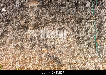 Vecchio intonaco grigio, parete di fondo beige texture. La struttura del muro di pietra sbiadita vuota e sbucciata invecchiata, la superficie vintage vuota per lo sfondo. Spazio di copia. Foto Stock