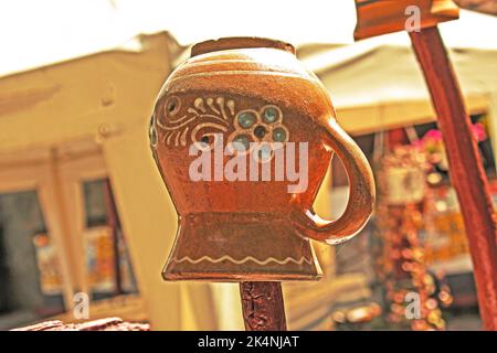 Una vecchia pentola di argilla Ucraina è asciugata su un bastone di legno. Foto Stock