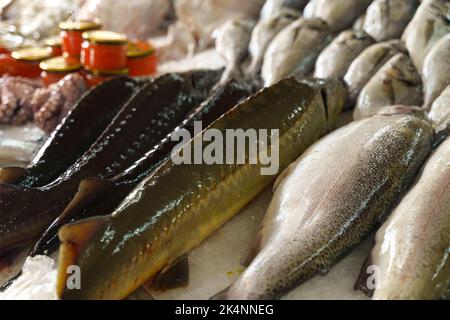 Pesce appena pescato e caviale in un vasetto sono sul banco del mercato. Primo piano. Foto Stock