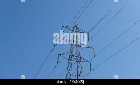 Elettricità pilone contro il cielo blu profondo con spazio per la copia Foto Stock