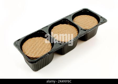 Tre pile di biscotti al cioccolato in confezione di plastica nera isolate su sfondo bianco Foto Stock