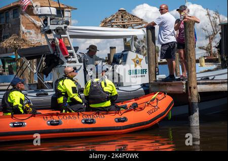 Guardia costiera membri della forza nazionale di attacco scannerizzare Pine Island, Florida per le persone in bisogno il 1 ottobre 2022. La squadra della National Strike Force nel sud-ovest della Florida ha assistito oltre 50 persone nella zona di Fort Myers. (STATI UNITI Guardia costiera foto di Petty Officer 3rd Classe Gabriel Wisdom) Foto Stock