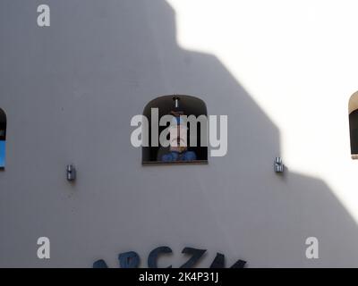 Toruń, Polonia - 7 agosto 2018: Edificio con diverse figure nelle nicchie della finestra Foto Stock