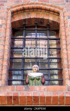 Toruń, Polonia - 7 agosto 2018: Edificio con diverse figure nelle nicchie della finestra Foto Stock
