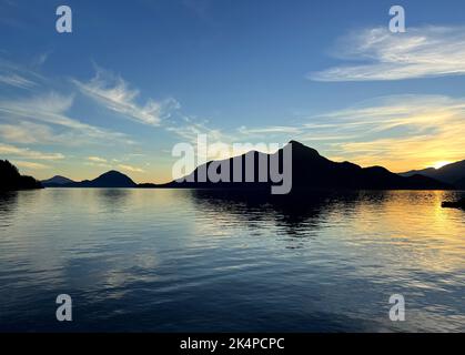 Background per l'agenzia di viaggi Porteau Cove Provincial Park Sunset città immersa nell'acqua che riflette nell'Oceano Pacifico creando un'immagine speculare la telecamera si muove lentamente catturando la bellezza della natura Foto Stock