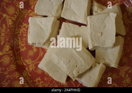 Formaggio tofu in piatto colorato su sfondo nero con spazio copia per il testo. Concetto di cibo sano Foto Stock