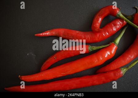 Peperoncino rosso caldo su sfondo scuro, vista dall'alto Foto Stock