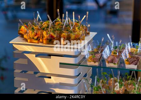 Il servizio di catering piastra .sandwich appetitosi su bastoncini in plastica rangeSandwiches su un tavolo del buffet. carne, pesce, verdura crostini su una festosa wedd Foto Stock