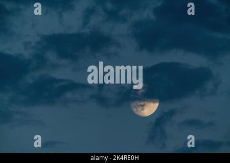 Luna crescente nelle nuvole sul cielo serale Foto Stock