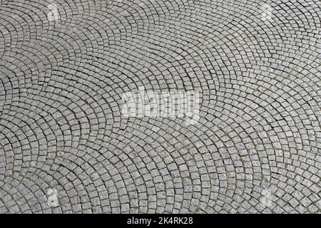 Pavimentazione in pietra naturale posata in archi a segmento Foto Stock