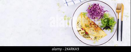 Dieta chetogenica prima colazione. Omelette con sorbetto e insalata fresca. Vista dall'alto, banner Foto Stock