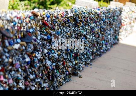 Lucchetti vecchi e nuovi con nomi e date scritte su di essi si bloccano su un ponte come segno d'amore a San Antonio, Texas. Foto Stock