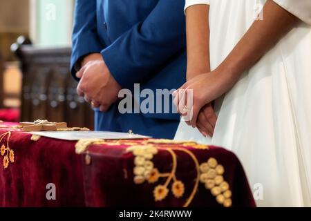 sposi novelli di fronte all'altare nella chiesa. vista ravvicinata Foto Stock