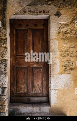 Vecchia porta di legno di una casa in pietra medievale nel villaggio di Saint Montan in Ardeche (sud della Francia) Foto Stock