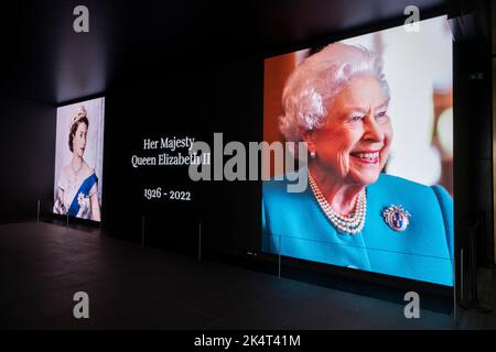 La gente interagisce con un'immagine della Regina, visualizzata su grandi schermi digitali presso l'edificio Oouternet il giorno successivo alla morte della Regina Elisabetta II il 9th settembre 2022 a Londra, Regno Unito. La regina, che aveva 96 anni, regnò come monarca del Regno Unito e del Commonwealth per 70 anni. Foto Stock