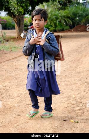 Pune, India - 21 settembre 2022, ragazza del villaggio indiano non identificata con un sacchetto della scuola va alla scuola. Foto Stock