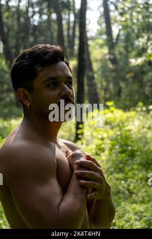 uomo visto da vicino, senza camicia che si allunga su tappetino yoga, esercizio fisico, america latina Foto Stock