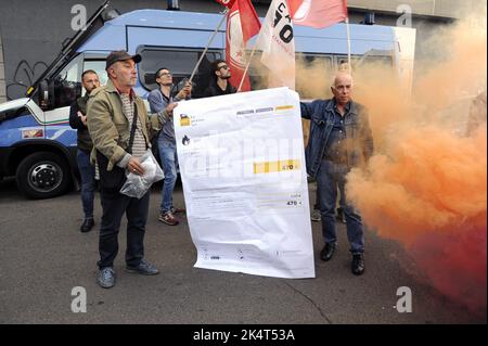 Milano, 2022 ottobre, i sindacati di base USB protestano di fronte all'ufficio cittadino dell'ENI contro l'aumento dei prezzi del gas a causa della crisi energetica internazionale e della speculazione. Un facsimile della fattura del gas è bruciato Foto Stock