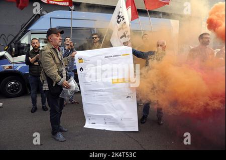 Milano, 2022 ottobre, i sindacati di base USB protestano di fronte all'ufficio cittadino dell'ENI contro l'aumento dei prezzi del gas a causa della crisi energetica internazionale e della speculazione. Un facsimile della fattura del gas è bruciato Foto Stock