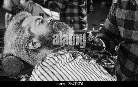 Capelli del viso. Mantenere la forma della barba. Fate crescere la barba e i baffi. Parrucchiere. Uomo al barbiere. Barbiere professionale e cliente. Barbiere è Foto Stock