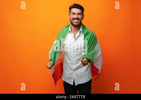 Ritratto di un giovane uomo casual con bandiera dell'Iran su sfondo arancione Foto Stock