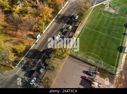 Vista aerea della città sul campo di calcio verde vicino alle strade autunnali della città, nel centro di Kharkiv, Ucraina Foto Stock