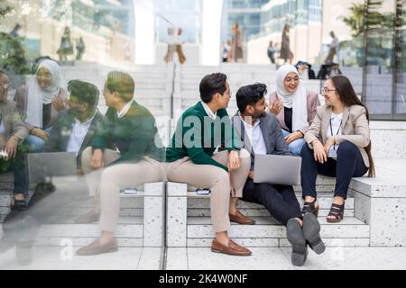 Gruppo multietnico di giovani uomini d'affari all'aperto in città Foto Stock