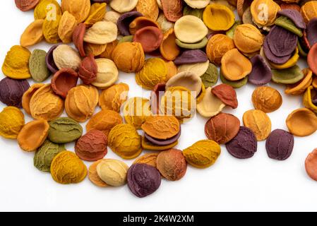 Orecchiette colorate, semola di grano duro italiano con curcuma, spinaci, barbabietole e carote nere isolate su bianco Foto Stock