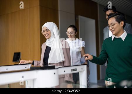 I giovani imprenditori entrano nel loro posto di lavoro attraverso i tornelli della sicurezza Foto Stock