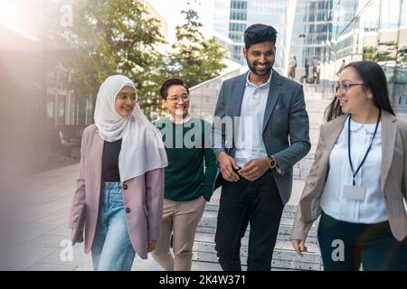Gruppo multietnico di giovani uomini d'affari all'aperto in città Foto Stock