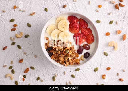 ciotola di cereali al granola con yogurt e frutti di bosco isolati su fondo bianco Foto Stock