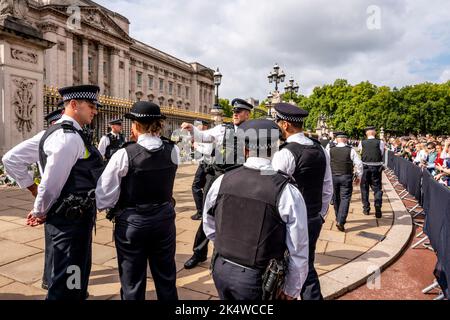 Il giorno dopo che la Regina Elisabetta II passa via gli ufficiali della polizia Metropolitana controllano la folla fuori da Buckingham Palace, Londra, Regno Unito Foto Stock