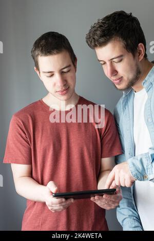 Primo piano ritratto di due uomini utilizzando un tablet digitale Foto Stock