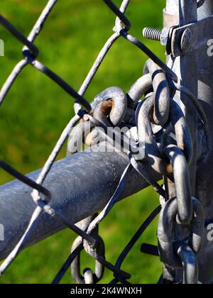 Catena bloccata sulla recinzione a catena per maggiore sicurezza Foto Stock