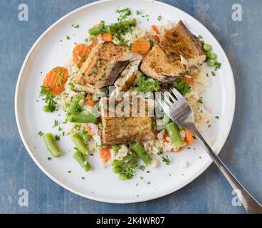 Sana cena o pranzo a base di pesce con salmone fritto in padella, verdure e riso integrale. Foto Stock