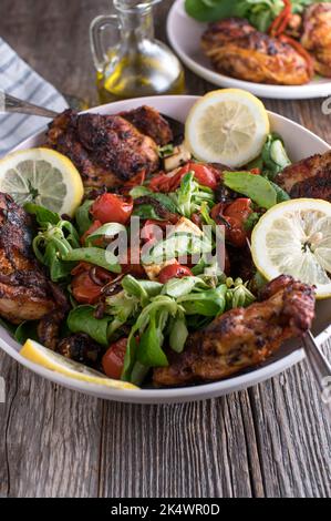 Cena a basso contenuto di carb con pollo fresco cotto al forno e scolpito e una deliziosa insalata con verdure arrosto e formaggio feta Foto Stock