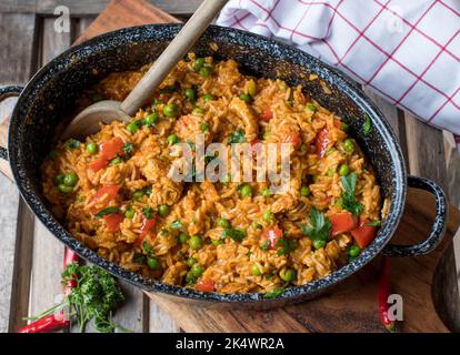 Riso djuvec serbo con carne di pollo. Servito in una pentola rustica isolata su un tavolo di legno. Vista dall'alto Foto Stock