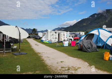 SANKT GILGEN, AUSTRIA - 2 AGOSTO 2022: Camper e tende in un campeggio vicino al lago Wolfgangsee, nella regione austriaca del Salzkammergut. Foto Stock
