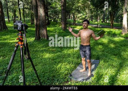 Un ragazzo con un tablet che fa video blog al telefono. Persona isolata che dà lezioni online. Uomo che dà lezioni on-line con il telefono. Foto Stock