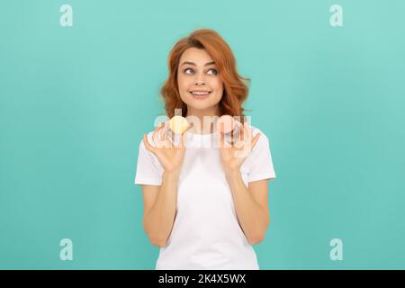 ragazza felice tenere dolce macaron biscotto francese su sfondo blu Foto Stock