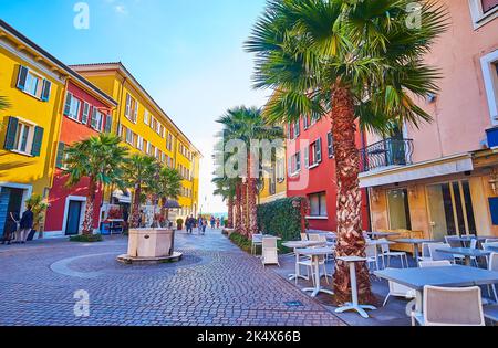 L'antico pozzo Antico Pozzo sulla piazza Castello, fiancheggiata da terrazze di caffè all'aperto, Sirmione, Italia Foto Stock
