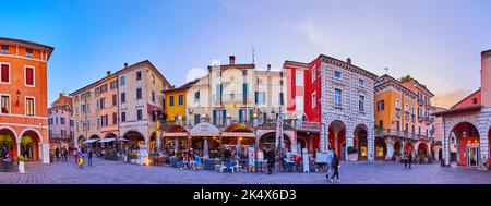 DESENZANO DEL GARDA, ITALIA - 10 APRILE 2022: Panorama serale Piazza Giuseppe Malvezzi con accoglienti ristoranti e case storiche, il 1 aprile Foto Stock