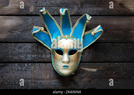 Maschera veneziana si trova su un tavolo di legno, maschera teatrale vintage Foto Stock