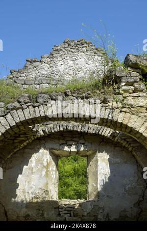Rovine di un antico tempio cristiano contro il cielo blu. Soffitto crollato. Muratura, sala con volte ad arco. L'erba cresce sulle pareti. Rashkov, Moldavia. Cl Foto Stock