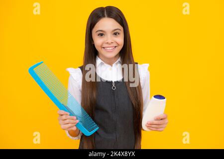 Ragazza adolescente con balsamo shampoo o gel doccia. Prodotti cosmetici per la cura dei capelli per bambini, bottiglia di shampoo. Foto Stock