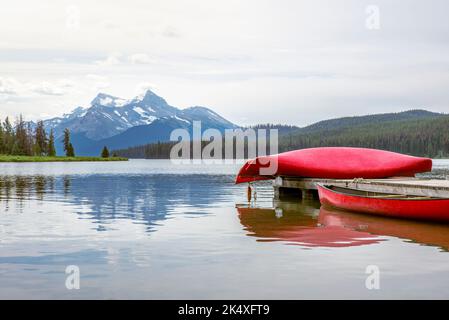 Canoe rosse sul molo sul Lago Maligne nel Parco Nazionale di Jasper Foto Stock