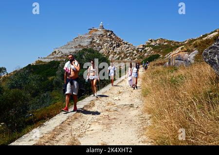 Turisti escursioni sul sentiero fino alla cima (con un faro) di Illa de Faro o Montefaro, Isole Cies, Galizia, Spagna Foto Stock