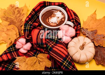 Composizione autunnale di una tazza di caffè con marshmallow su fondo giallo Foto Stock