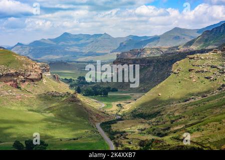 Guardando giù su una strada che si snoda attraverso la valle nel Golden Gate Highlands National Park. Vista dalla cima del Brandwag Buttress (Sentinel) rock Foto Stock